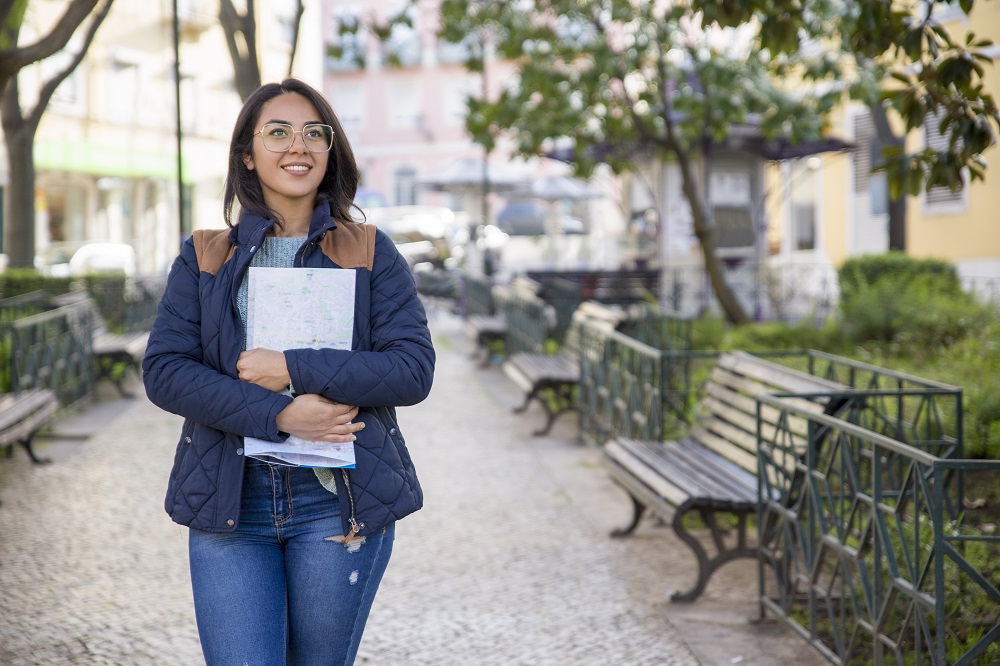 Estudante segurando cadernos, caminhando pelo campus, representando quem acabou de entrar na UFBRA.